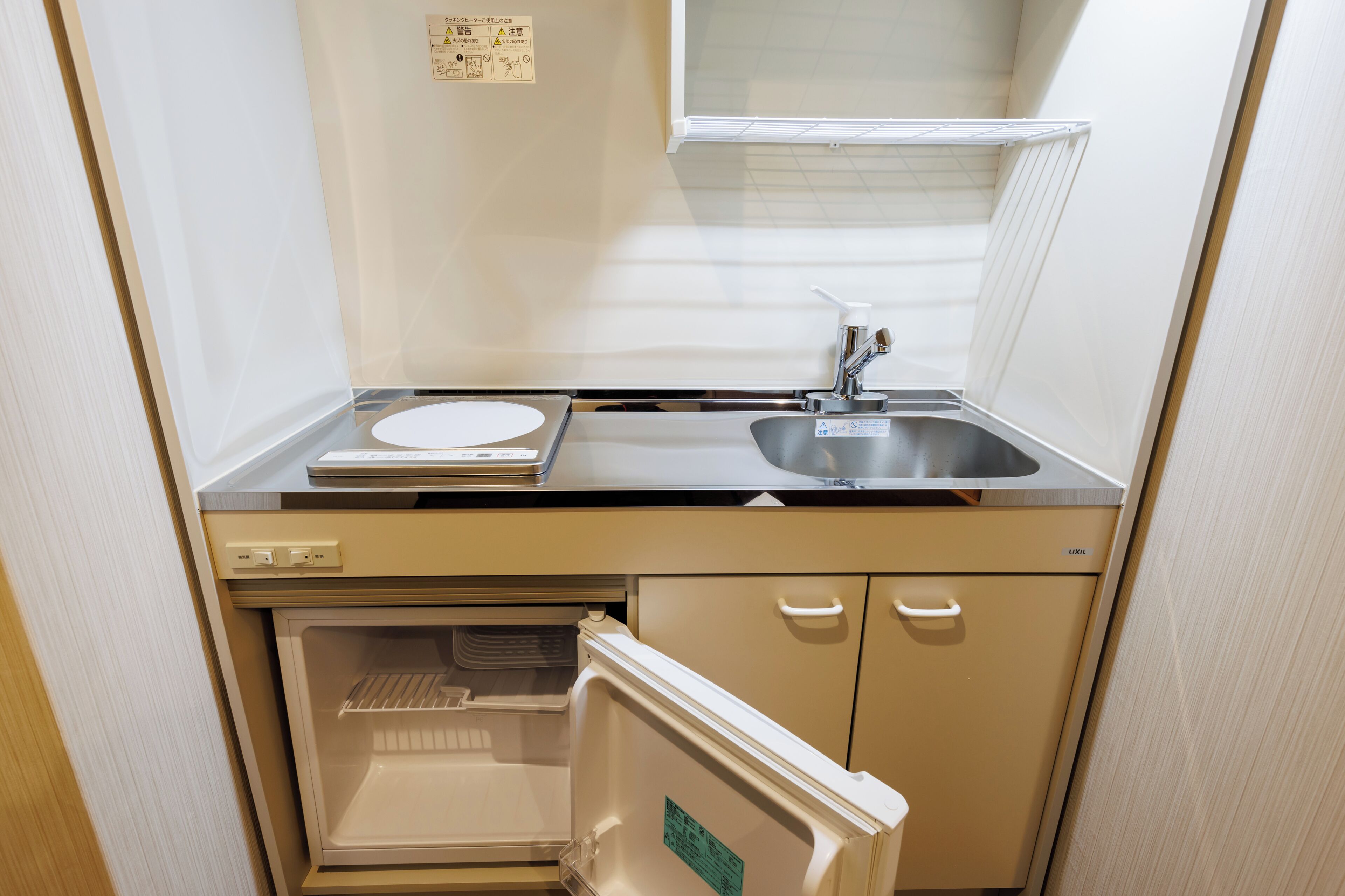 Une petite cuisine équipée comprenant un réfrigérateur, un évier et un petit plan de travail.