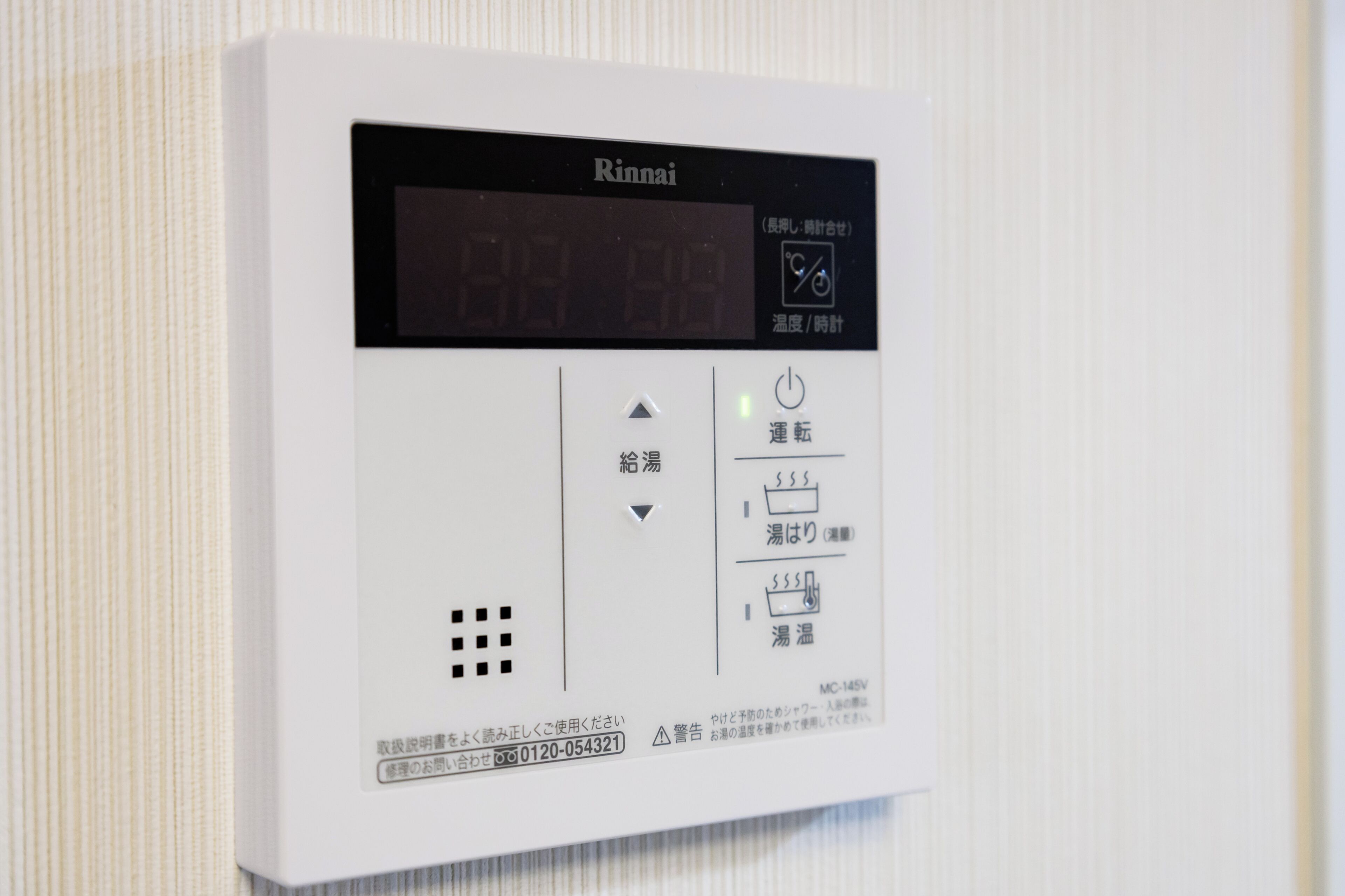 A white Rinnai water heater with a digital display, control buttons, and a temperature setting indicator.