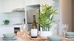 Een eettafel met een wijnfles, een potplant en verschillende kommen en wijnglazen.