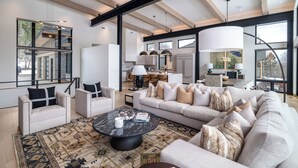 A spacious living area with a large sofa, a coffee table, and a view of the kitchen and dining area. - Luxury 4 bd home on Rollingstone Ranch Golf Course (Steamboat Springs)