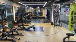 A gym with weightlifting equipment, a basketball court, and a boxing equipment banner. - Feng Zheng Hotel (Guangzhou)