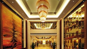 A spacious lobby with a large chandelier, a reception desk, and a high ceiling. - Feng Zheng Hotel (Guangzhou)