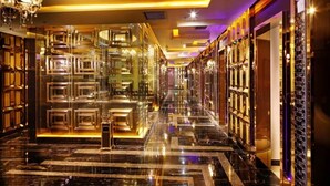 A luxurious hotel corridor with reflective flooring, ornate chandeliers, and glass partitions. - Feng Zheng Hotel (Guangzhou)