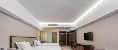 Camera d'albergo con un letto, una scrivania, una sedia, una televisione e un bagno visibile sullo sfondo.