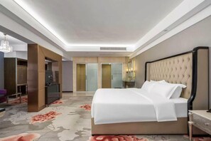 A hotel room with a large bed, a wardrobe, a mirror, and a carpeted floor. - Feng Zheng Hotel (Guangzhou)