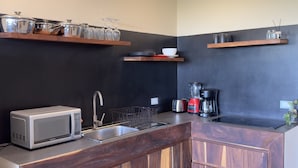 Et køkken med mikrobølgeovn, vask, brødrister og kaffemaskine.