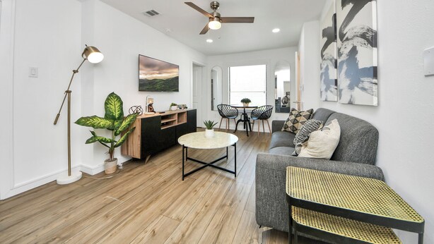 A modern living room with a sofa, coffee table, and dining area. - Arbor Flats #4 in the Heart of Houston (Houston)