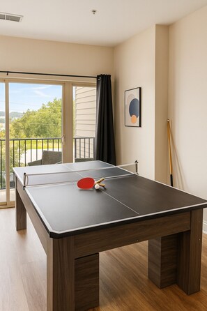 A ping pong table in a room with a balcony, a painting on the wall, and a pool cue. - Family & Group Retreat|3 Queens Beds Pool Table 11 (Birmingham)