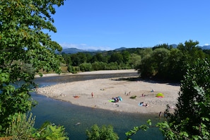 A riverside area with people, boats, and tents. - GRANDFATHER'S APARTMENT IN CANGAS DE ONIS (Cangas De Onis)