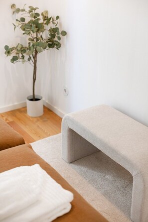 A room with a bench, a small potted plant, and a white wall. - Sal D’Ouro Atlantic Living | Gym & Garage (Vila Nova de Gaia)