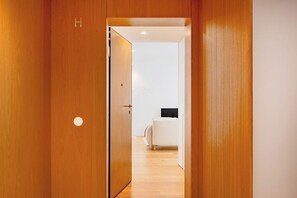 A wooden door with a circular handle and a letter 'H' on the wall. - Sal D’Ouro Atlantic Living | Gym & Garage (Vila Nova de Gaia)