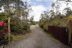 A gravel path leading to a building with a wooden fence on one side.