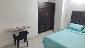 A bedroom with a bed, a wardrobe, a chair, and a small table. - Comfortable room with separate entrance (Barrancabermeja)
