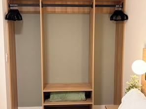 A wooden wardrobe with two black hangers, a light fixture, and a green pillow. - High Floor 3-Bdr Apartment with Incredible Views, Pool & 24/7 Gym G4416 (Miami)