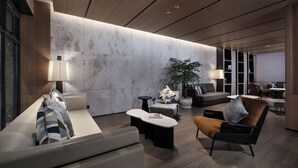 Eine moderne Lobby mit Marmorwand, einer Sitzgelegenheit und einer großen Pflanze in einem Topf.