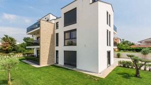 Un edificio moderno a due piani con tetto piatto, ampie finestre e facciata in pietra.