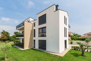 Ein modernes, zweistöckiges Gebäude mit flachem Dach, großen Fenstern und einer Steinfassade.