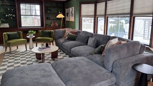 Una sala de estar con un sofá modular, dos sillones, una mesa de centro y una lámpara.