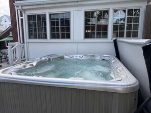 A hot tub in an outdoor setting with a house in the background. - Lux Colonial Home: Hot tub, Game Room, Home Theatre, Karaoke (Framingham)