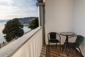 Ein Balkon mit Blick auf ein Gewässer und eine ferne Skyline.
