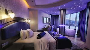 Una camera da letto moderna con un grande letto, una toeletta e vista sulla città.