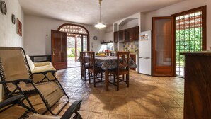 A dining area with a table, chairs, a ceiling fan, and a kitchen in the background. - Pet friendly home in Marsala with house sea view (Marsala)