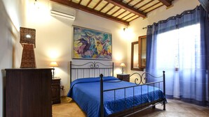 A bedroom with a bed, a dresser, a painting, a mirror, and a window with curtains. - Pet friendly home in Marsala with house sea view (Marsala)