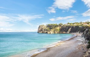 A coastal landscape with a clear sky, a pebble beach, and a cliff with vegetation. - 2 bedroom lovely home in Castellammare del Golf (Castellammare del Golf)