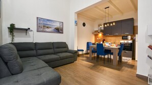 A modern living room with a sofa and a dining area with chairs and a table. - 2 bedroom lovely home in Castellammare del Golf (Castellammare del Golf)