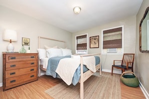 A bedroom with a bed, dresser, chair, and artwork on the walls. - Charming House in Lawrenceville, Pittsburgh; next to Butler St- 4BR, 2bth & yard (Pittsburgh)