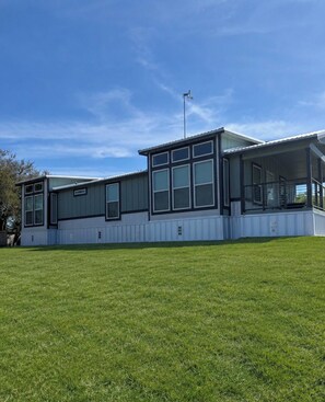 A modern two-story building with large windows and a covered porch area.