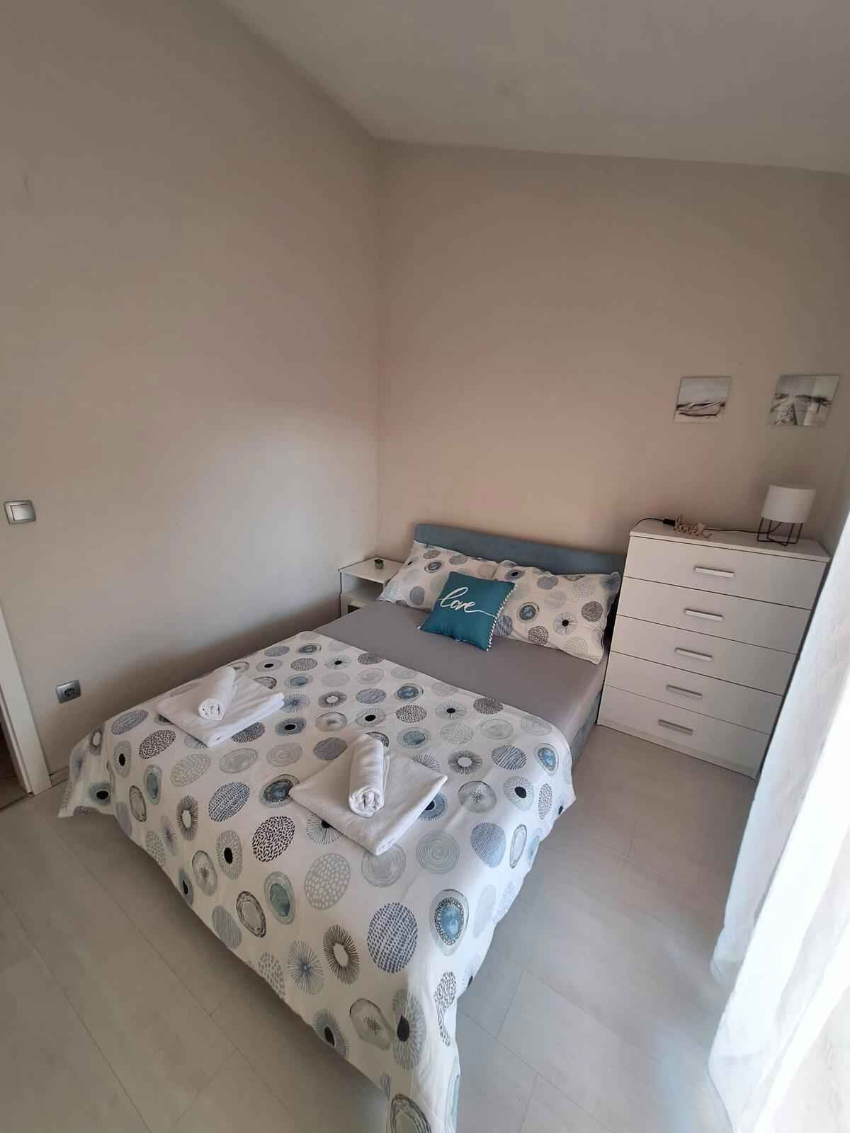 Une chambre à coucher avec un lit, une commode et une table de chevet.
