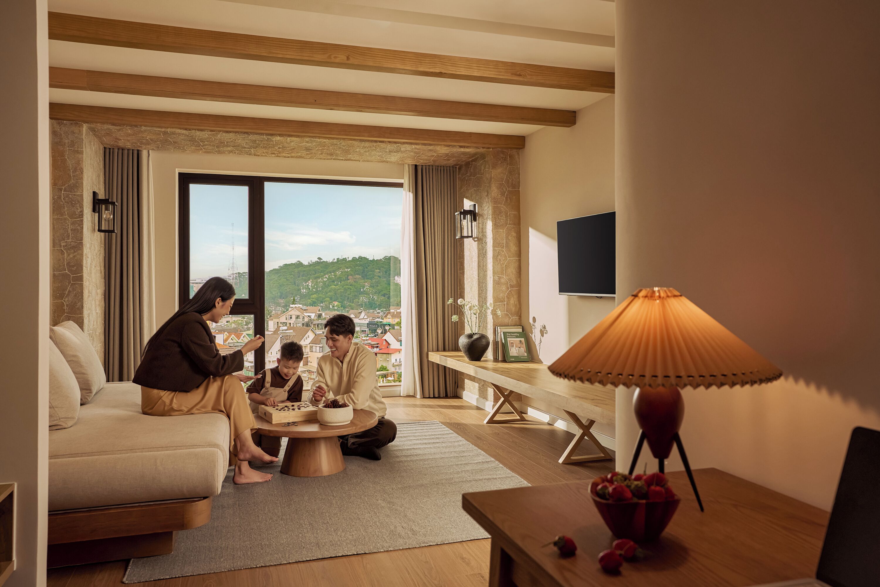 Un salon moderne avec un canapé, une table basse ronde, une lampe et un téléviseur.