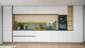 A modern kitchen with white cabinetry, a built-in oven, and a coffee machine. - Holiday Apartment Sabbia 6+0 (Srima)