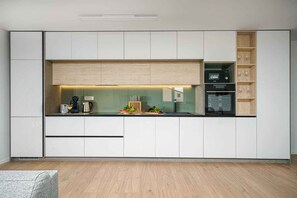 A modern kitchen with white cabinetry, a built-in oven, and a coffee machine. - Holiday Apartment Sabbia 6+0 (Srima)