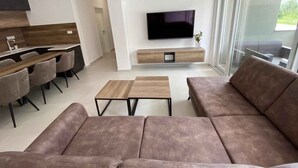 A modern living room with a sofa, coffee table, TV, and dining area. - Holiday Apartment APARTMENT EMANUEL (4+1) (Vodice)