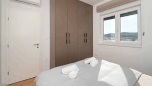 Una camera da letto con un letto, un armadio, un condizionatore d'aria e una finestra vista.