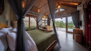 Una camera da letto con un letto grande, una scrivania e vista sull'esterno.