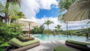 Una piscina al aire libre, sombrillas, sillones reclinables de piscina