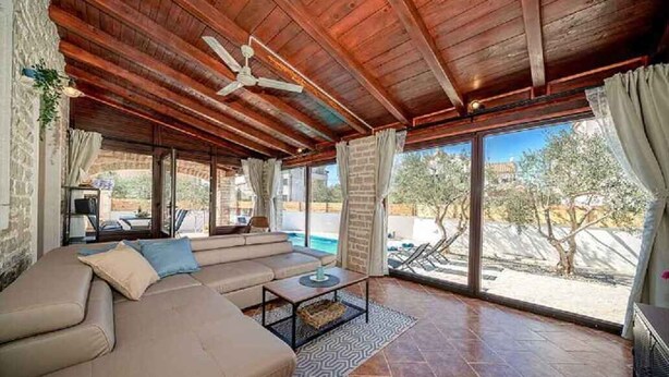 A covered outdoor seating area with a sofa, a table, and a ceiling fan. - Villa VILLA MARIJANA 6+0 (Srima)