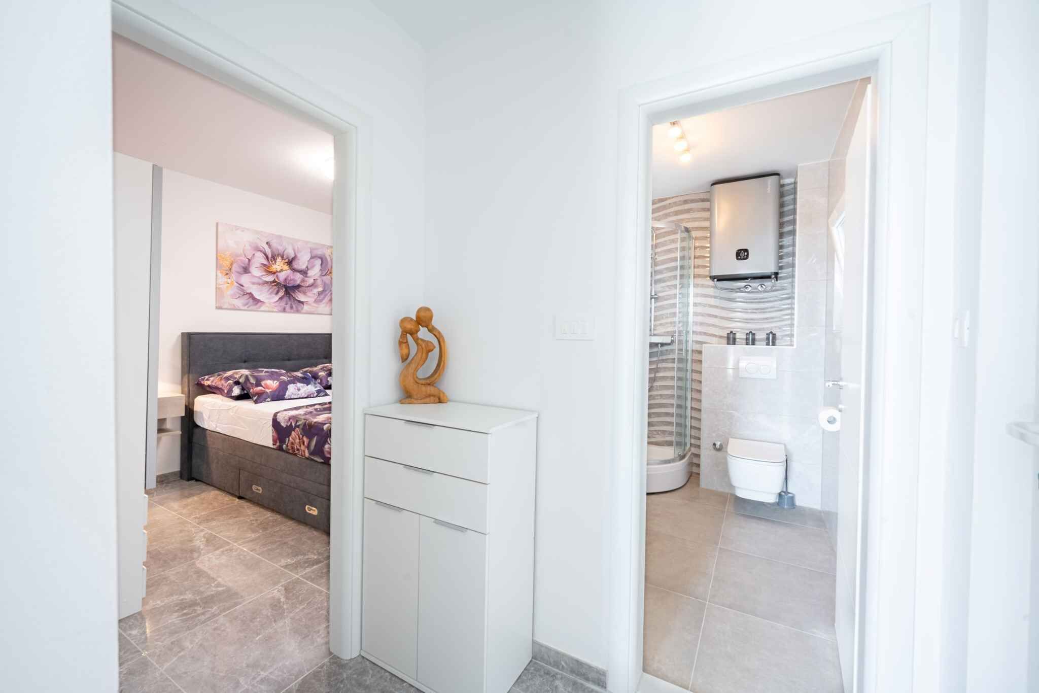 A bedroom with a bed, bedside table, and a wall-mounted artwork.