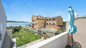 A balcony with a view of a body of water and a building with multiple balconies. - Holiday Apartment GORAN DADIĆ APP 2 (4+0) (Srima)