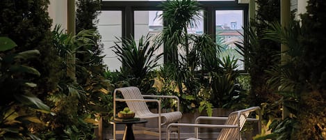Un vaste atrium intérieur doté de hauts plafonds, de grandes fenêtres et de nombreux espaces de détente, le tout agrémenté d’une végétation luxuriante.