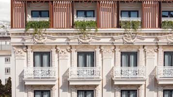 Ein Gebäude mit aufwendigen architektonischen Details, darunter Verzierungen an Balkonen und Fenstern.