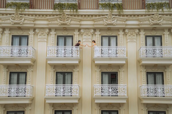 A building with ornate balconies and decorative moldings.