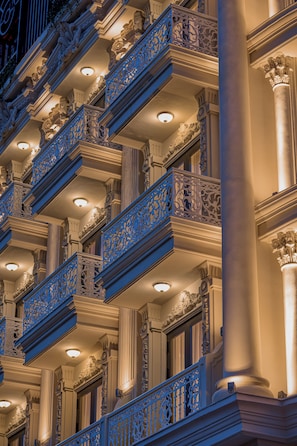 Fachada de edifício com varandas ornamentadas e colunas.