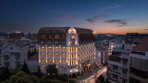 A multi-story hotel with a classic architectural design, featuring balconies and a prominent entrance.