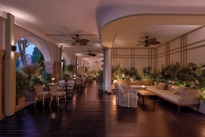 A spacious indoor area with wooden flooring, seating arrangements, ceiling fans, and potted plants. - Signature by M Village The Central Da Lat, a brand of Modern Village Lifestyle (Xuan Huong - Da Lat)