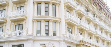 Un edificio histórico con balcones ornamentales y un estilo arquitectónico clásico.