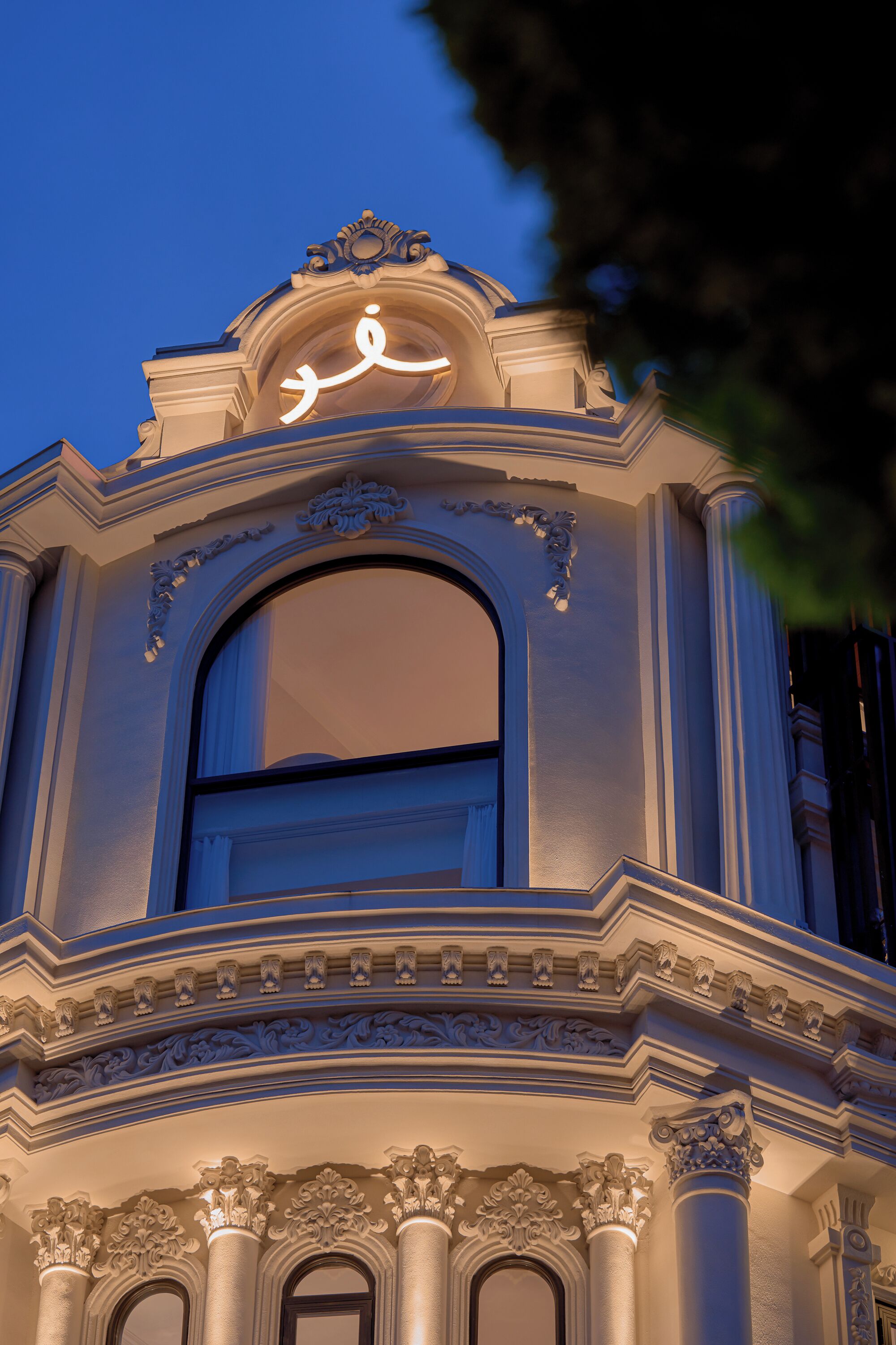 An ornate architectural structure with a large arched window and decorative moldings.